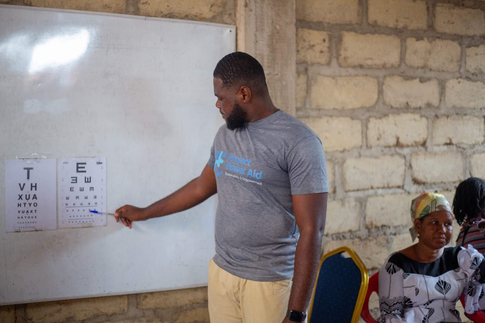 Volunteer conducting vision chart test